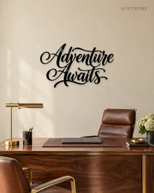 Adventure Awaits brush script wall art in gloss piano black acrylic, float-mounted above a console table on a pale plaster wall