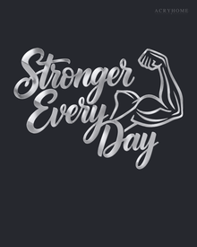 Stronger Every Day script wall art with flexed-arm icon in mirror silver acrylic, mounted above a dumbbell rack.