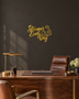 Stronger Every Day script wall art with flexed-arm icon in mirror gold acrylic, catching light on a pale gym wall.