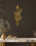 Unalome and lotus line wall art in mirror gold acrylic, catching warm light against a pale wall.