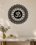 Gloss black acrylic Om sunburst mandala wall art, float-mounted on a pale wall with layered petal and diamond rings around the central Om symbol