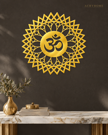 Mirror gold acrylic Om mandala wall art with geometric sunburst rings, float-mounted and catching warm light on a neutral wall