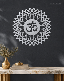 Mirror silver acrylic Om sunburst mandala wall art, float-mounted so the layered petal rings cast a soft shadow on the wall