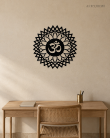 Gloss black acrylic Om sunburst mandala wall art, float-mounted on a pale wall with layered petal and diamond rings around the central Om symbol
