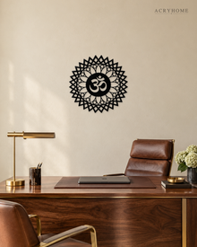 Gloss black acrylic Om sunburst mandala wall art, float-mounted on a pale wall with layered petal and diamond rings around the central Om symbol