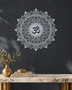 Om lotus mandala acrylic wall art in mirror silver, float-mounted on a cool graphite wall