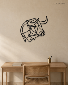 Bull's head drawn as one continuous line, laser-cut in gloss piano black acrylic and float-mounted on a pale wall.