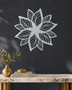 Layered Bloom flower wall art in Silver mirror chrome acrylic, geometric petals radiating from a central point on a pale wall.