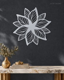 Layered Bloom flower wall art in mirror silver acrylic, geometric petals radiating from a central point on a pale wall.