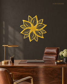 Layered Bloom flower wall art in mirror gold acrylic, layered petals catching light above a living room wall.