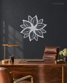Layered Bloom flower wall art in mirror silver acrylic, geometric petals radiating from a central point on a pale wall.