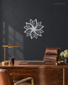 Layered Bloom flower wall art in mirror silver acrylic, geometric petals radiating from a central point on a pale wall.