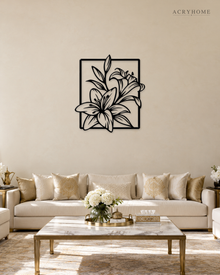 Lily line art wall piece in gloss piano black acrylic, stems and long leaves crossing a thin rectangular frame, float-mounted on a pale wall.