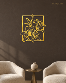 Lily line art wall piece in mirror gold acrylic, fine stems and leaves breaking past a slim rectangular frame, float-mounted above a console.
