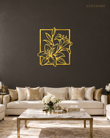 Lily line art wall piece in mirror gold acrylic, fine stems and leaves breaking past a slim rectangular frame, float-mounted above a console.