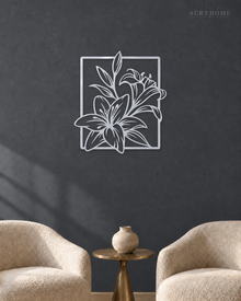 Lily line art wall piece in mirror silver acrylic, leaves reaching beyond a thin rectangular frame, float-mounted so the line lifts off the wall.