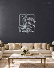 Lily line art wall piece in mirror silver acrylic, leaves reaching beyond a thin rectangular frame, float-mounted so the line lifts off the wall.