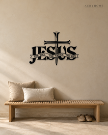 JESUS wall art in gloss piano black acrylic, heavy block letters with a cross and nails set into the lettering and a banner beneath reading The Way, The Truth, The Life, float-mounted on a pale wall