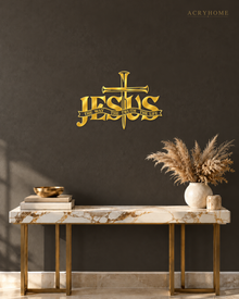 JESUS wall art in mirror gold acrylic, heavy block letters with a cross and nails set into the lettering and a banner beneath reading The Way, The Truth, The Life, float-mounted on a pale wall