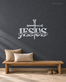 JESUS wall art in mirror silver acrylic, heavy block letters with a cross and nails set into the lettering and a banner beneath reading The Way, The Truth, The Life, float-mounted on a pale wall