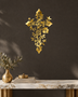 Floral filigree cross wall art in mirror gold acrylic, vines and blossoms catching warm light