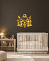 Silhouette of Jesus with arms outstretched above kneeling children, laser-cut in mirror gold acrylic and float-mounted on a pale wall.