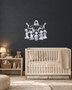 Silhouette of Jesus with arms outstretched above kneeling children, laser-cut in mirror silver acrylic and float-mounted on a pale wall.