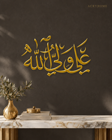 Ali un Waliyullah Arabic Calligraphy Acrylic Wall Art in mirror gold acrylic, float-mounted on a deep charcoal wall