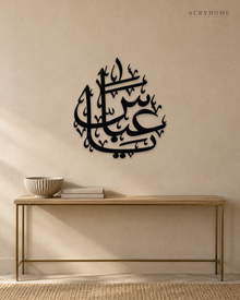 Arabic name calligraphy wall piece in gloss piano black acrylic, float-mounted above a pale console table.