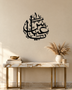 Arabic name calligraphy wall piece in gloss piano black acrylic, float-mounted above a pale console table.