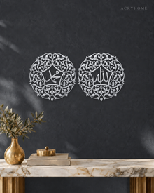 Pair of Arabic Calligraphy Roundels Wall Art in mirror silver acrylic, float-mounted on a deep graphite wall.