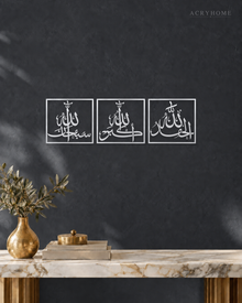 Fine Line Arabic Dhikr Squares - Wall Art, Set of Three in mirror silver acrylic, float-mounted on a deep graphite wall.