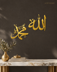 Allah and Muhammad Arabic Calligraphy Pair in mirror gold acrylic, float-mounted on a deep charcoal wall.