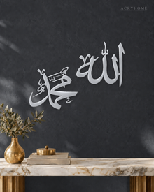 Allah and Muhammad Arabic Calligraphy Pair in mirror silver acrylic, float-mounted on a deep graphite wall.