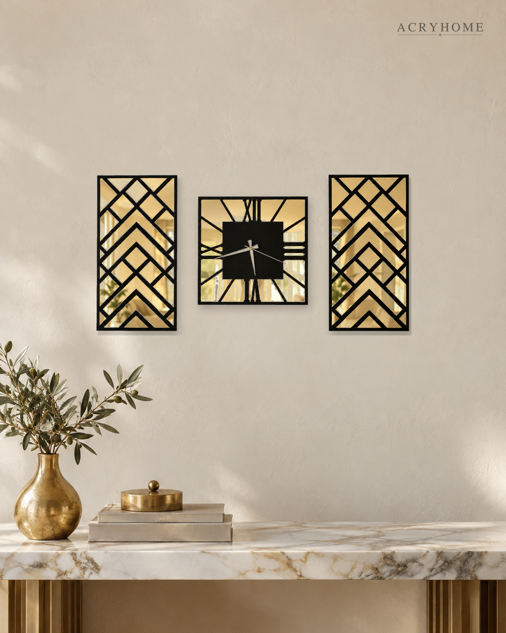 Art deco chevron clock and mirror panel set of three in black and gold mirror acrylic, on a pale wall.