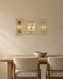 Gold mirror three-piece clock and panel set hung above a sofa in a living room.