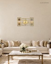 Gold mirror three-piece clock and panel set hung above a sofa in a living room.