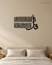 Surah An-Nas Thuluth Panel — Acrylic Islamic Wall Art in gloss piano black acrylic, float-mounted on a warm ivory wall
