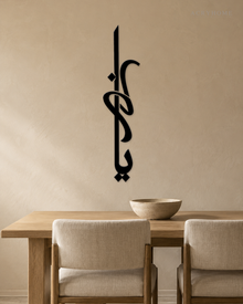 Vertical Arabic Calligraphy Panel — Acrylic Islamic Wall Art in gloss piano black acrylic, float-mounted on a warm ivory wall