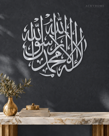Shahada Roundel — Acrylic Islamic Wall Art in mirror silver acrylic, float-mounted on a deep graphite wall