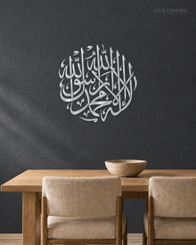 Shahada Roundel — Acrylic Islamic Wall Art in mirror silver acrylic, float-mounted on a deep graphite wall