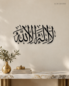 La Ilaha Illa Allah Thuluth Panel in gloss piano black acrylic, float-mounted on a warm ivory wall
