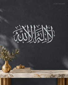 La Ilaha Illa Allah Thuluth Panel in mirror silver acrylic, float-mounted on a deep graphite wall